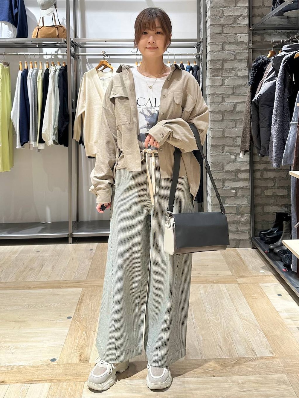 ブラック系のブルゾン、その他のショルダーバッグ、ベージュ系のシャツ/ブラウスを着用したレディースの冬コーディネートの5枚目の写真