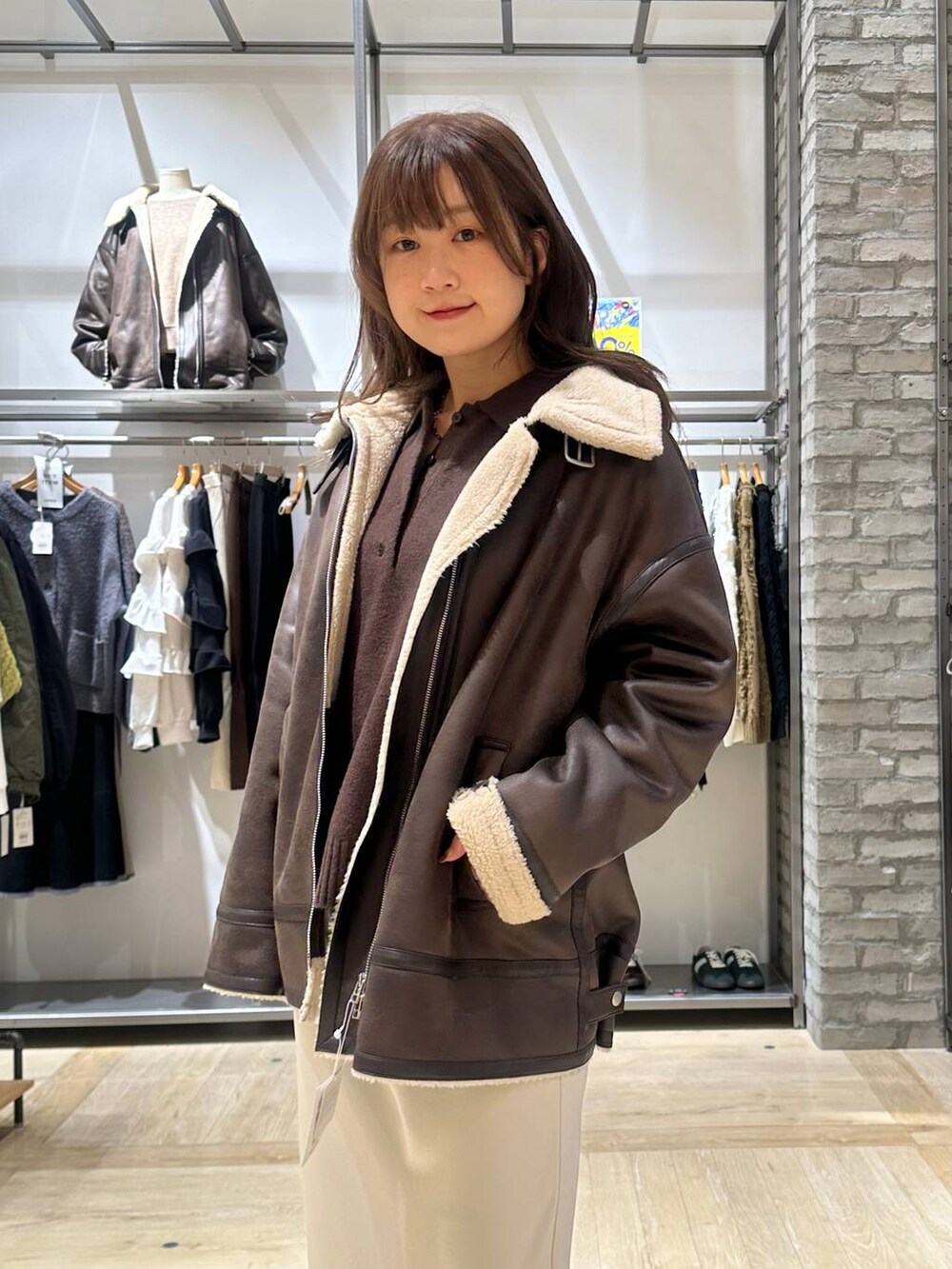 ホワイト系のスカート、ブラウン系のニット/セーター、ブラウン系のその他アウターを着用したレディースの秋コーディネートの4枚目の写真