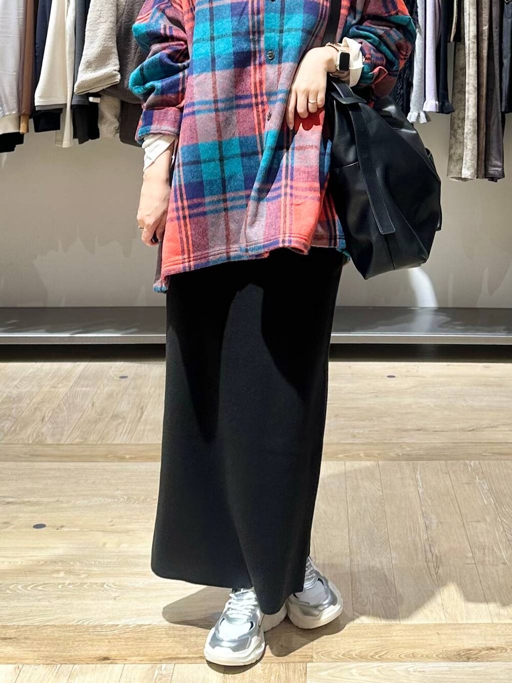 ブラック系のスカート、ホワイト系のスニーカー、ブラック系のショルダーバッグを着用したレディースの秋コーディネートの5枚目の写真