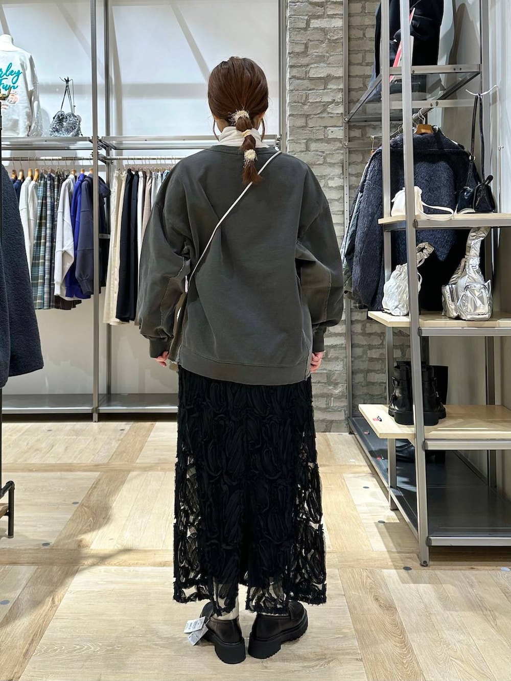 ブラック系のポンチョ、ブラック系のローファー、シルバー系のショルダーバッグを着用したレディースの冬コーディネートの6枚目の写真