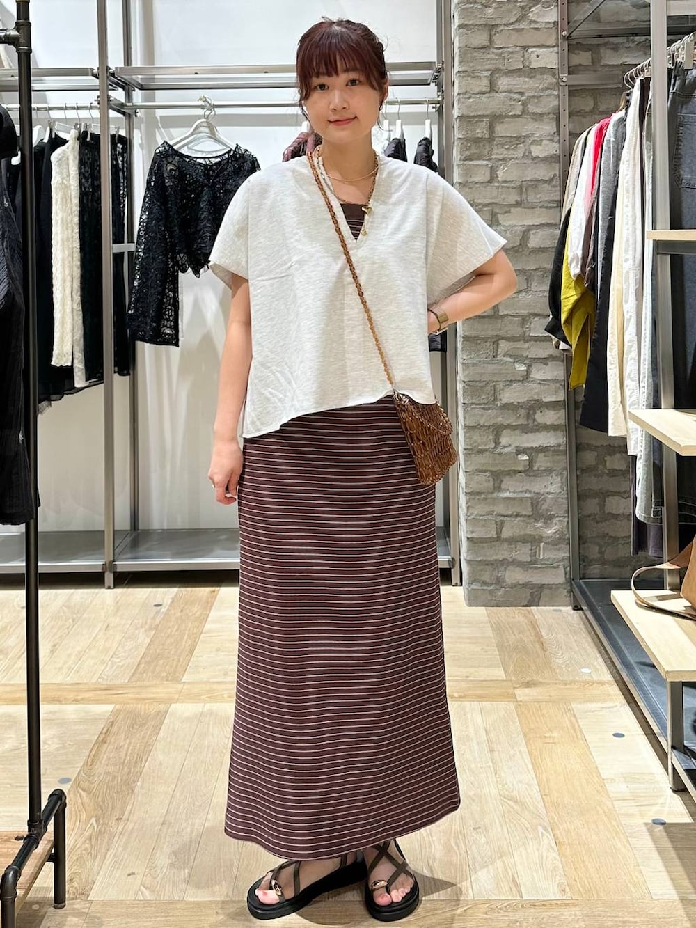 ブラウン系のサンダル、ブラウン系のショルダーバッグ、グレー系のTシャツ/カットソーを着用したレディースの夏コーディネートの2枚目の写真