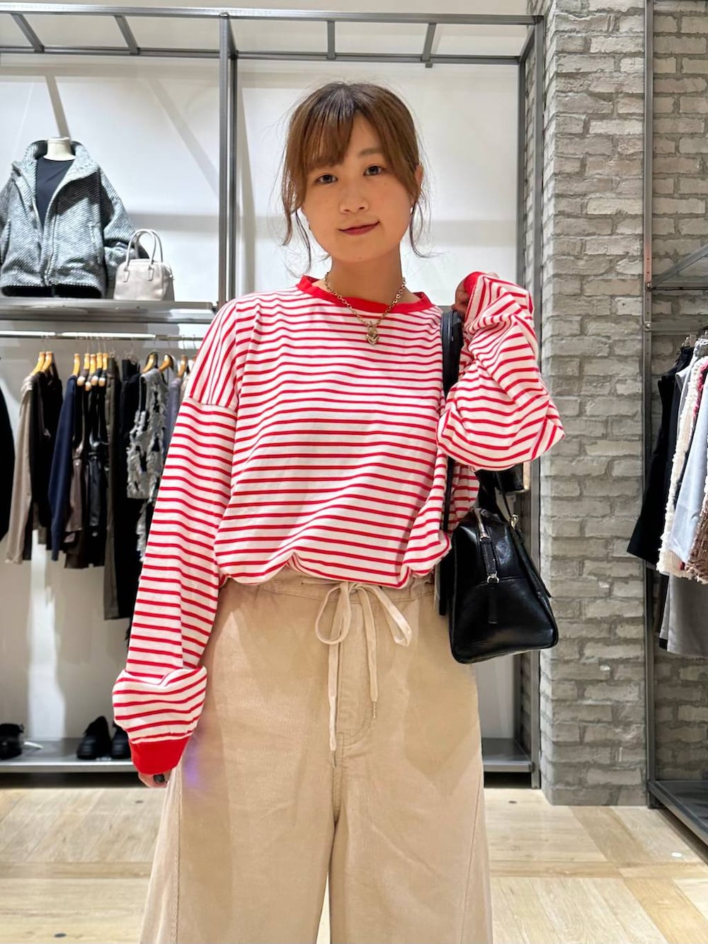 レッド系のTシャツ/カットソー、ブラック系のサンダル、ホワイト系のその他パンツを着用したレディースの秋コーディネートの5枚目の写真