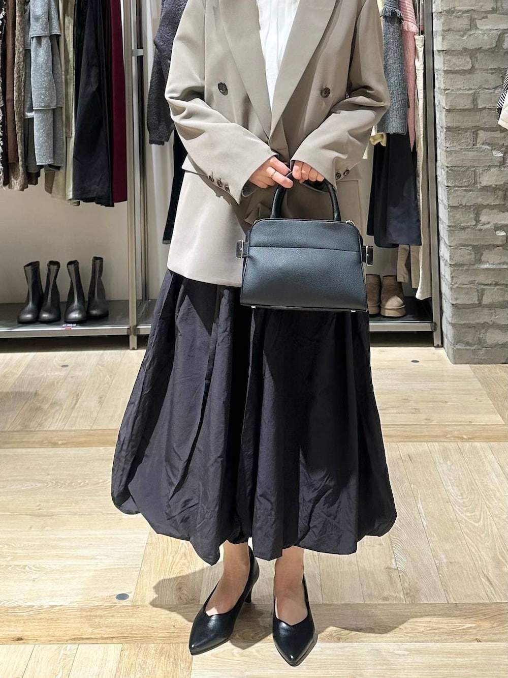 ブラウン系のテーラードジャケット、ブラック系のスカート、ホワイト系のシャツ/ブラウスを着用したレディースの冬コーディネートの5枚目の写真