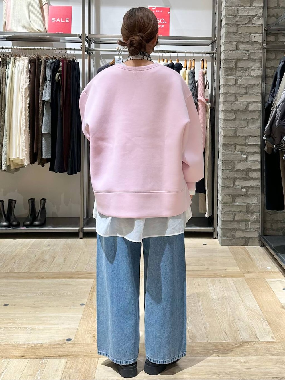 ブラック系のショルダーバッグ、ホワイト系のTシャツ/カットソー、ブラック系のブーツを着用したレディースの冬コーディネートの3枚目の写真