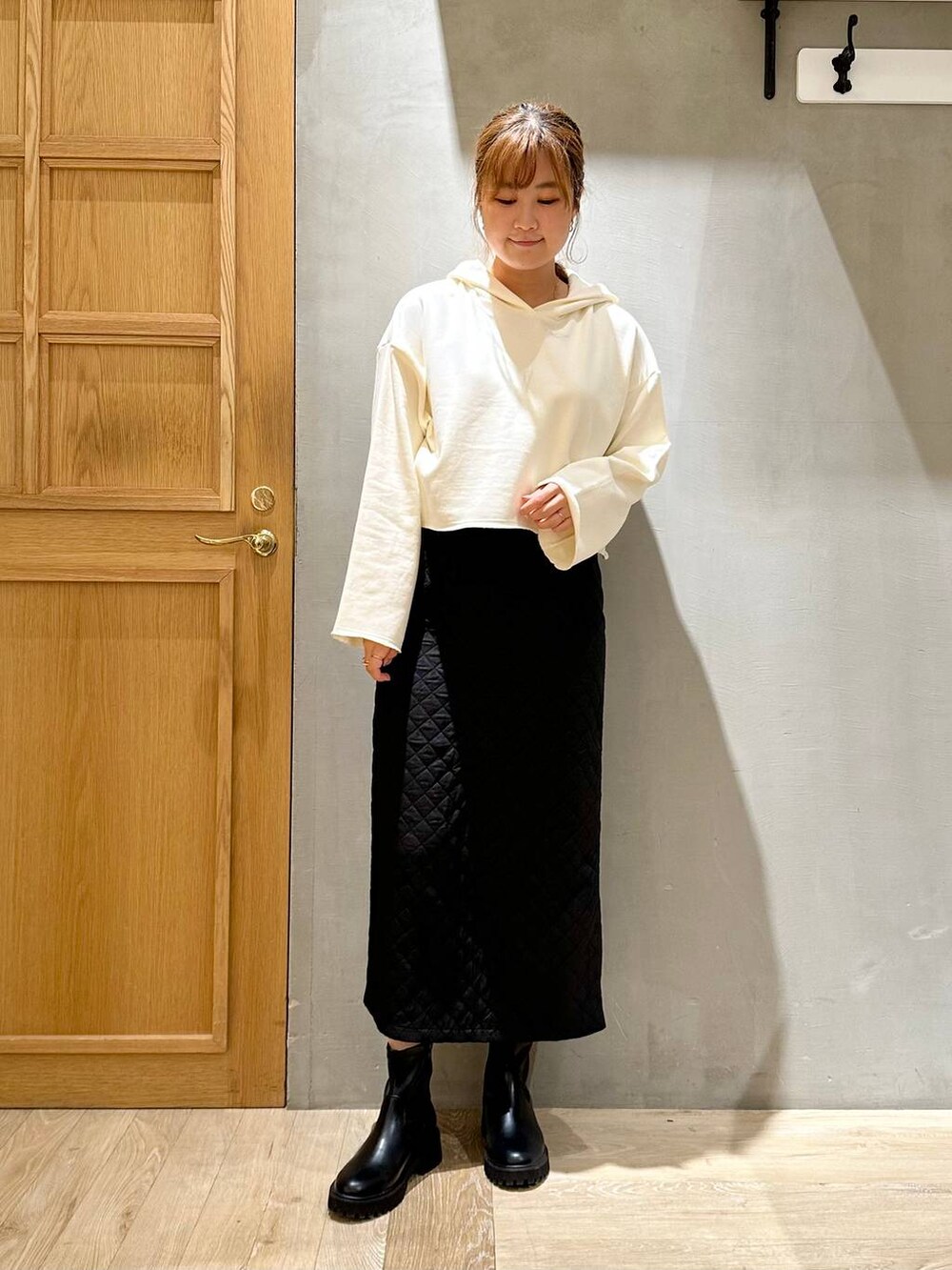 ホワイト系のパーカー、ブラック系のショルダーバッグ、ブラック系のスカートを着用したレディースの秋コーディネートの5枚目の写真