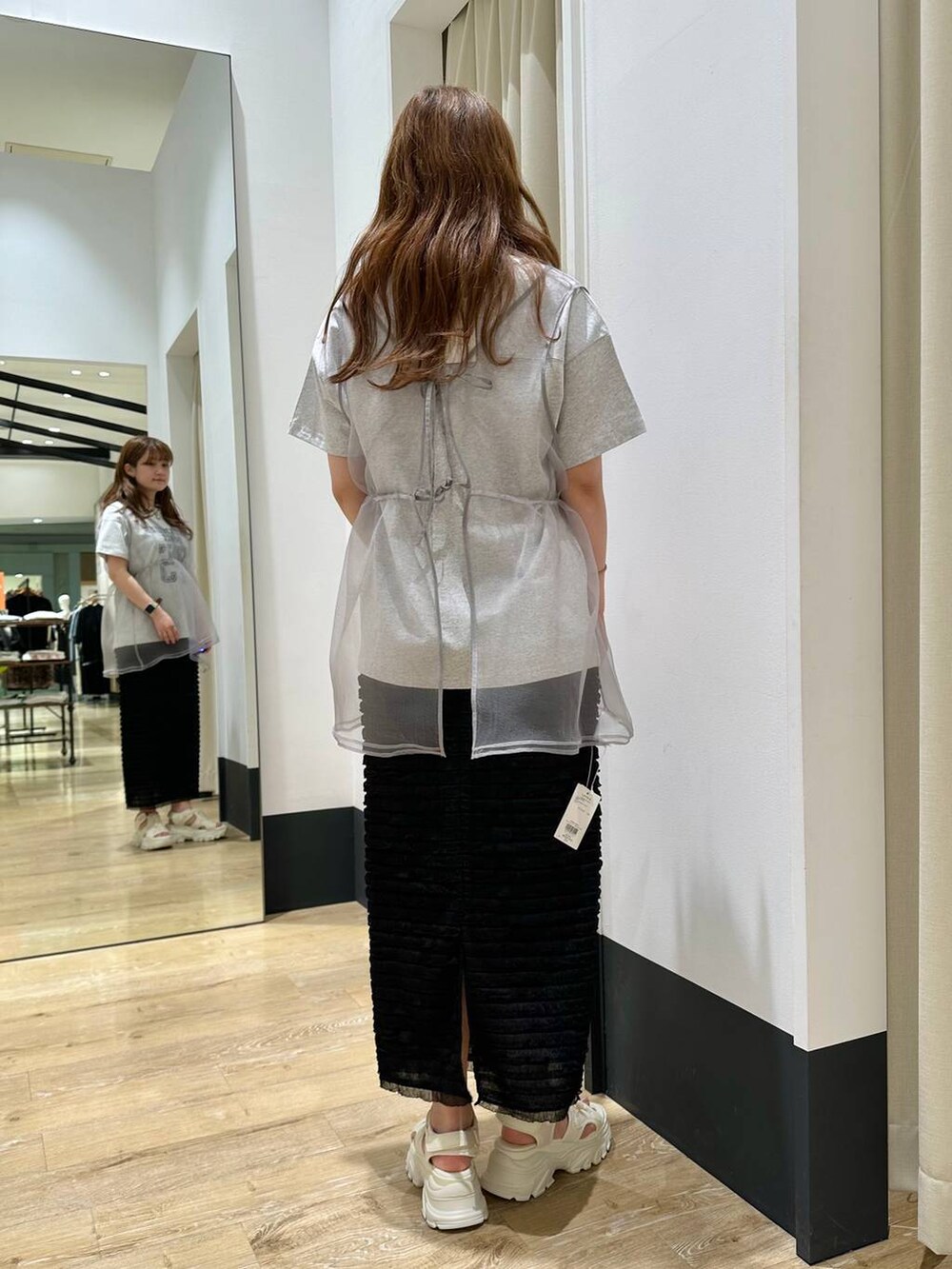 ホワイト系のサンダル、グレー系のベスト、ブラック系のスカートを着用したレディースの春コーディネートの4枚目の写真