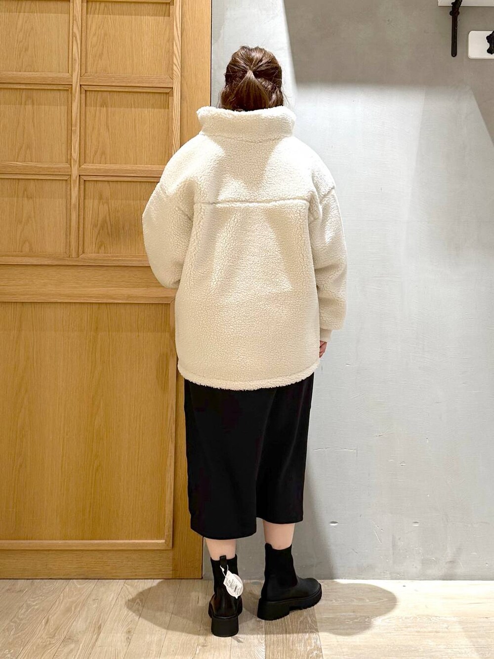 ブラック系のワンピース、ブラック系のブーツ、シルバー系のトートバッグを着用したレディースの冬コーディネートの4枚目の写真