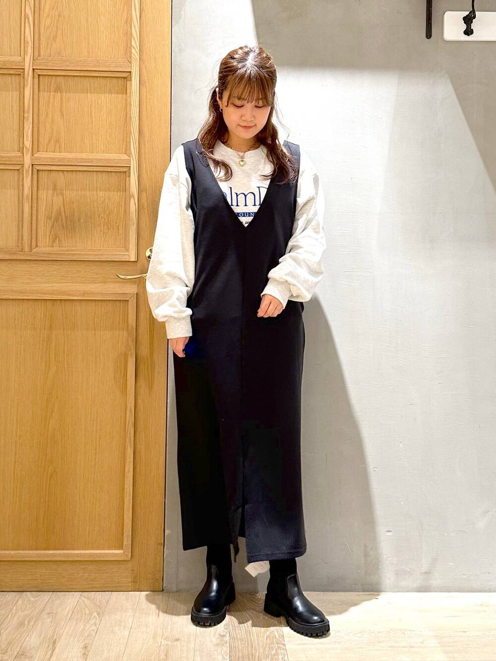 ブラック系のワンピース、ブラック系のブーツ、シルバー系のトートバッグを着用したレディースの冬コーディネートの2枚目の写真