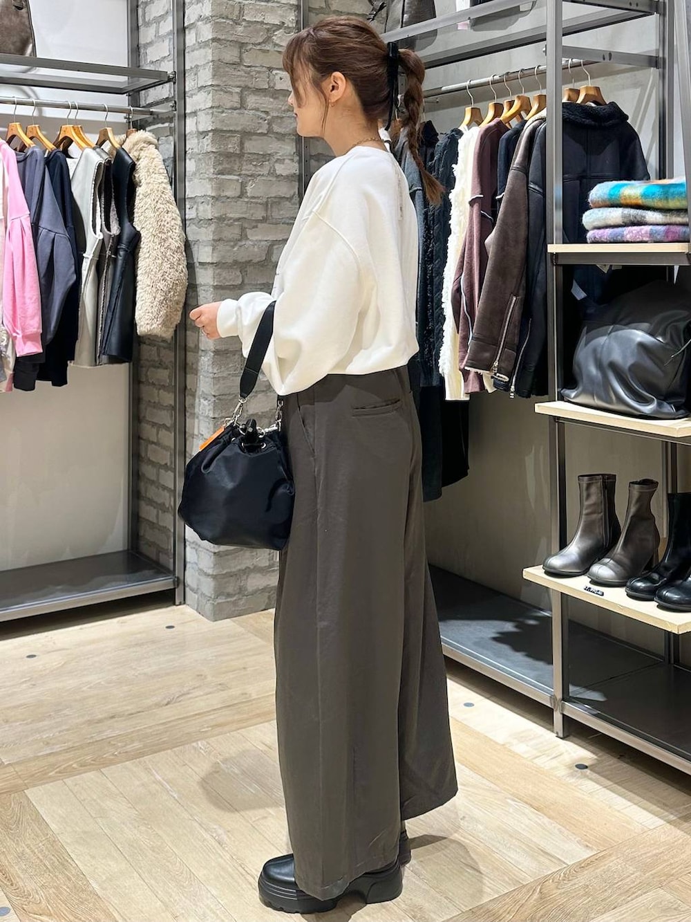 ブラック系のショルダーバッグ、ホワイト系のブルゾン、グレー系のその他パンツを着用したレディースの冬コーディネートの2枚目の写真