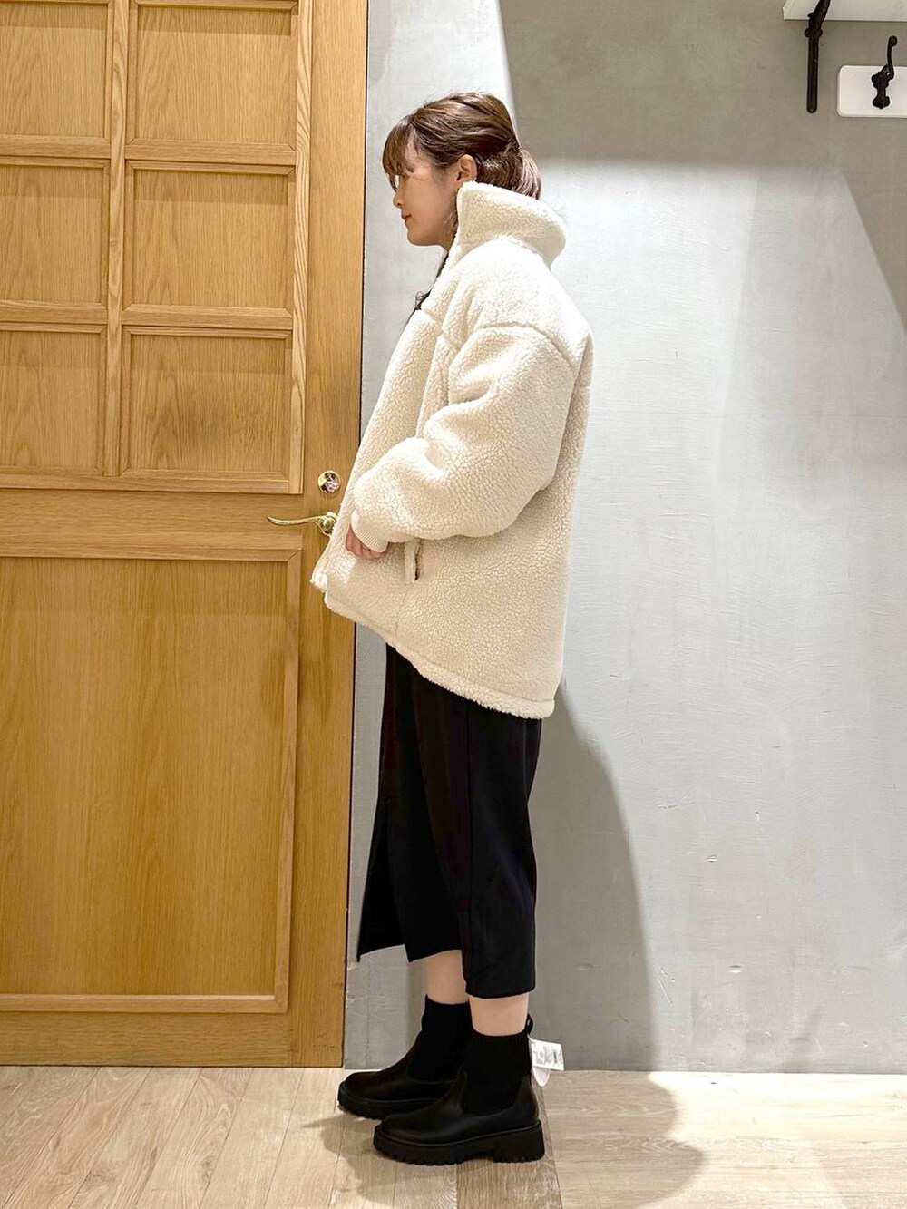 ブラック系のワンピース、ブラック系のブーツ、シルバー系のトートバッグを着用したレディースの冬コーディネートの3枚目の写真