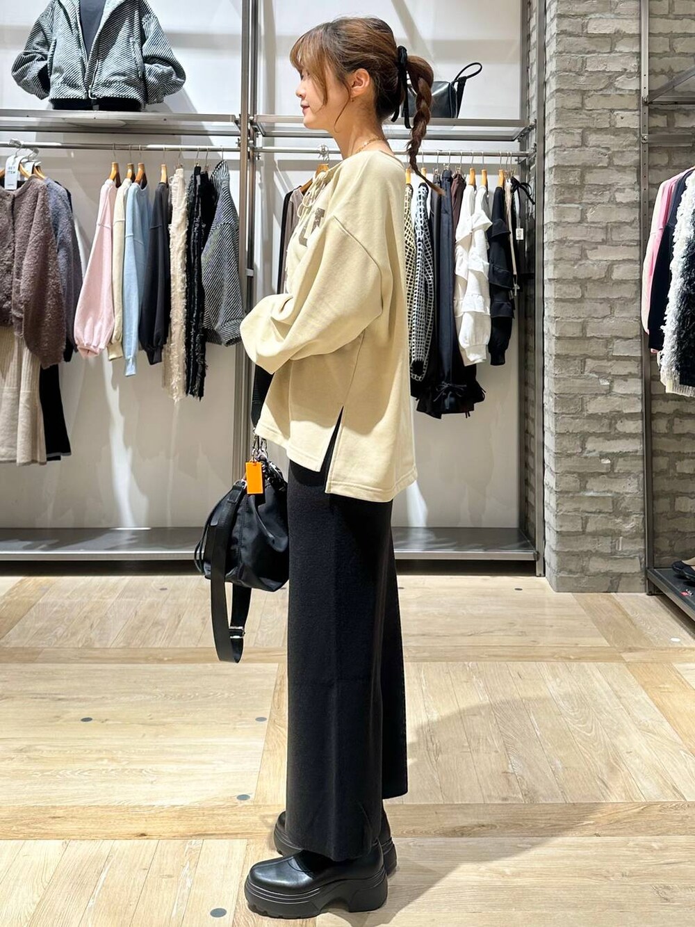 ブラック系のショルダーバッグ、ブラック系のスカート、ホワイト系のその他アウターを着用したレディースの秋コーディネートの3枚目の写真