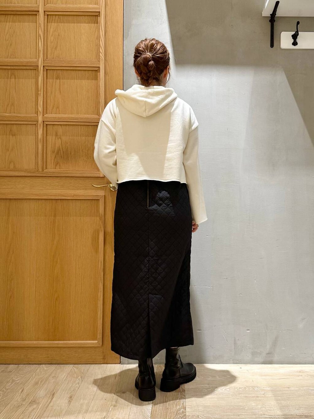ホワイト系のパーカー、ブラック系のショルダーバッグ、ブラック系のスカートを着用したレディースの秋コーディネートの7枚目の写真
