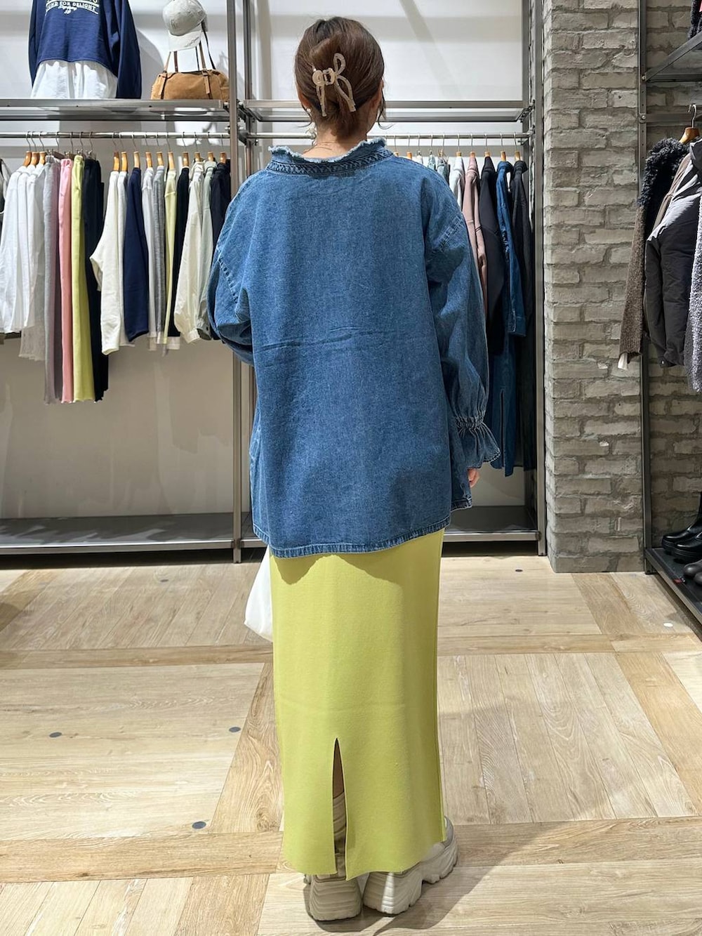 グリーン系のスカート、ブラック系のTシャツ/カットソー、ホワイト系のトートバッグを着用したレディースの冬コーディネートの4枚目の写真