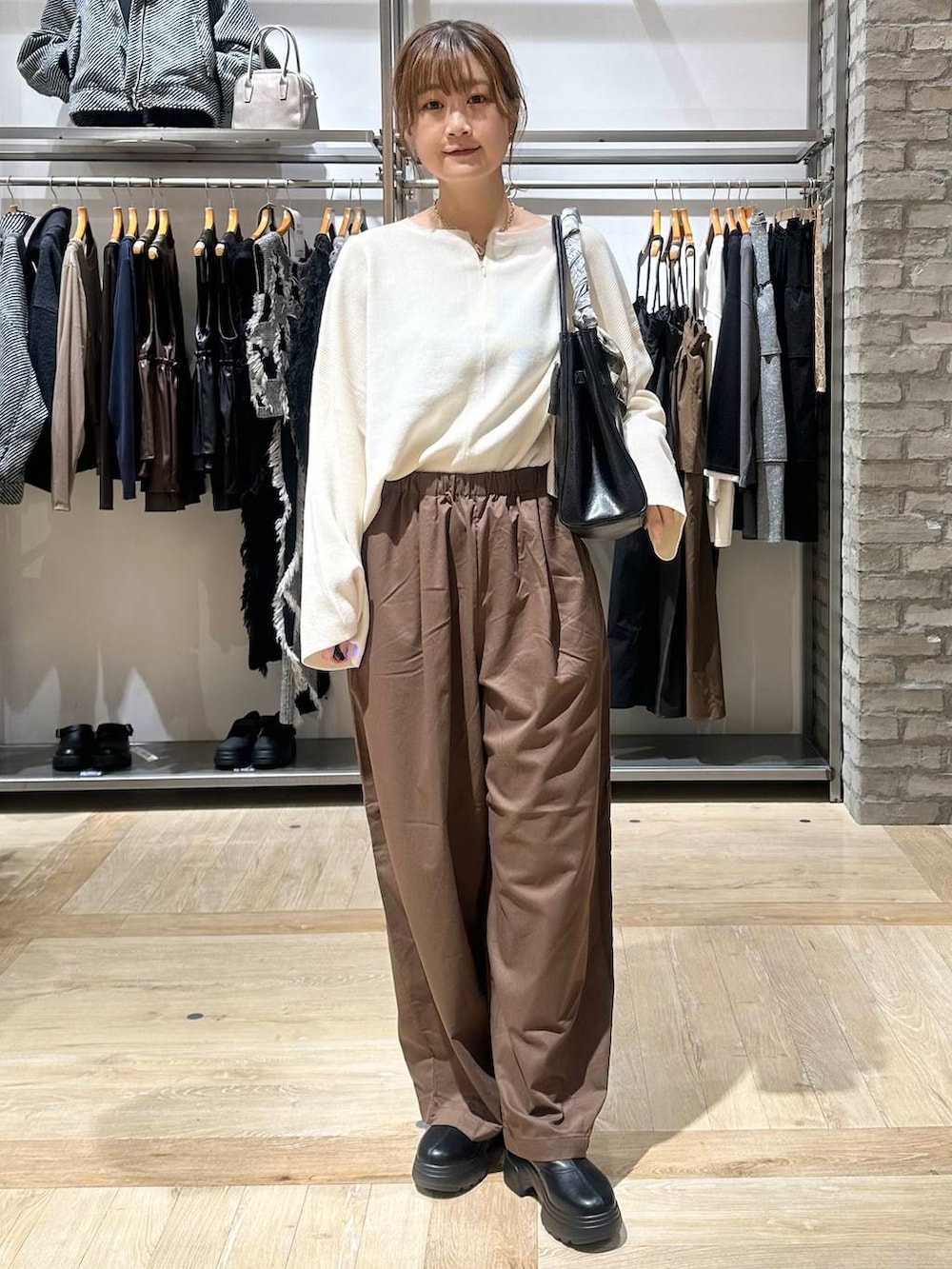 ホワイト系のニット/セーター、ブラック系のショルダーバッグ、ブラウン系のその他パンツを着用したレディースの秋コーディネートの5枚目の写真