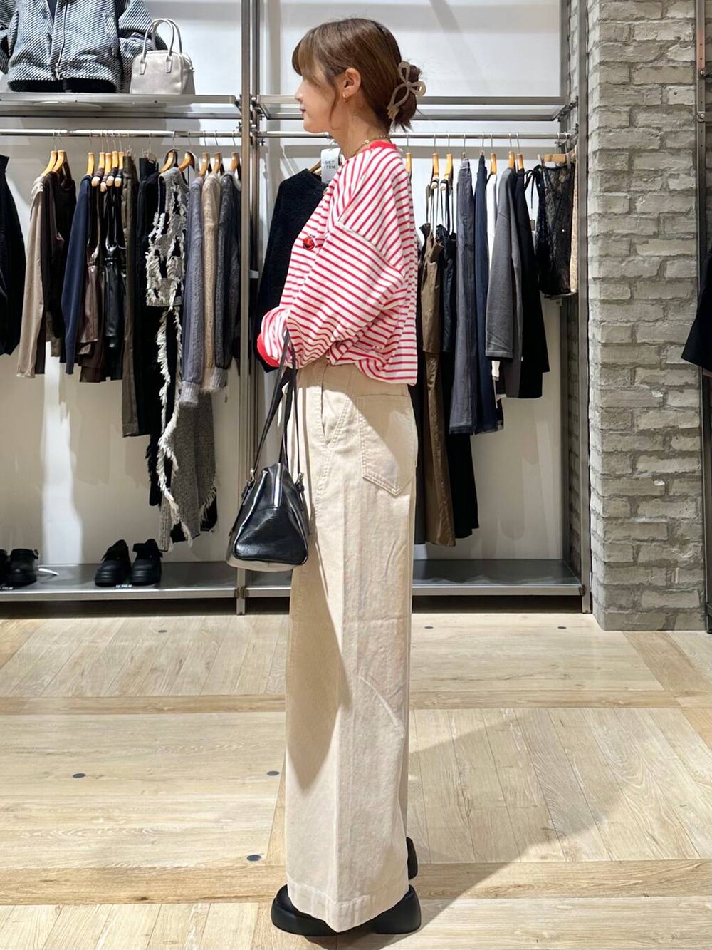 レッド系のTシャツ/カットソー、ブラック系のサンダル、ホワイト系のその他パンツを着用したレディースの秋コーディネートの3枚目の写真