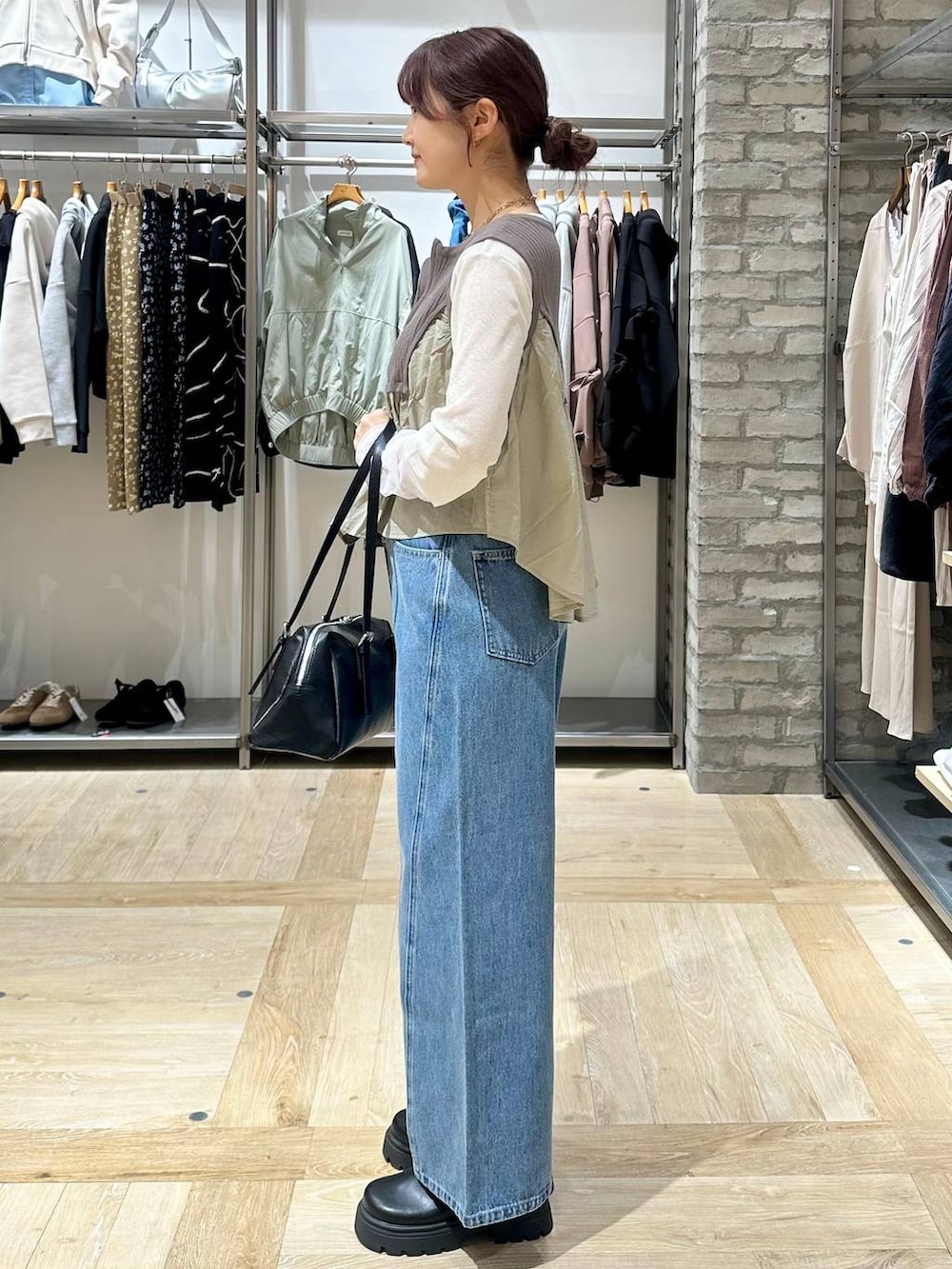 ホワイト系のTシャツ/カットソー、ブラック系のボストンバッグ、ブルー系のデニムパンツを着用したレディースの春コーディネートの2枚目の写真