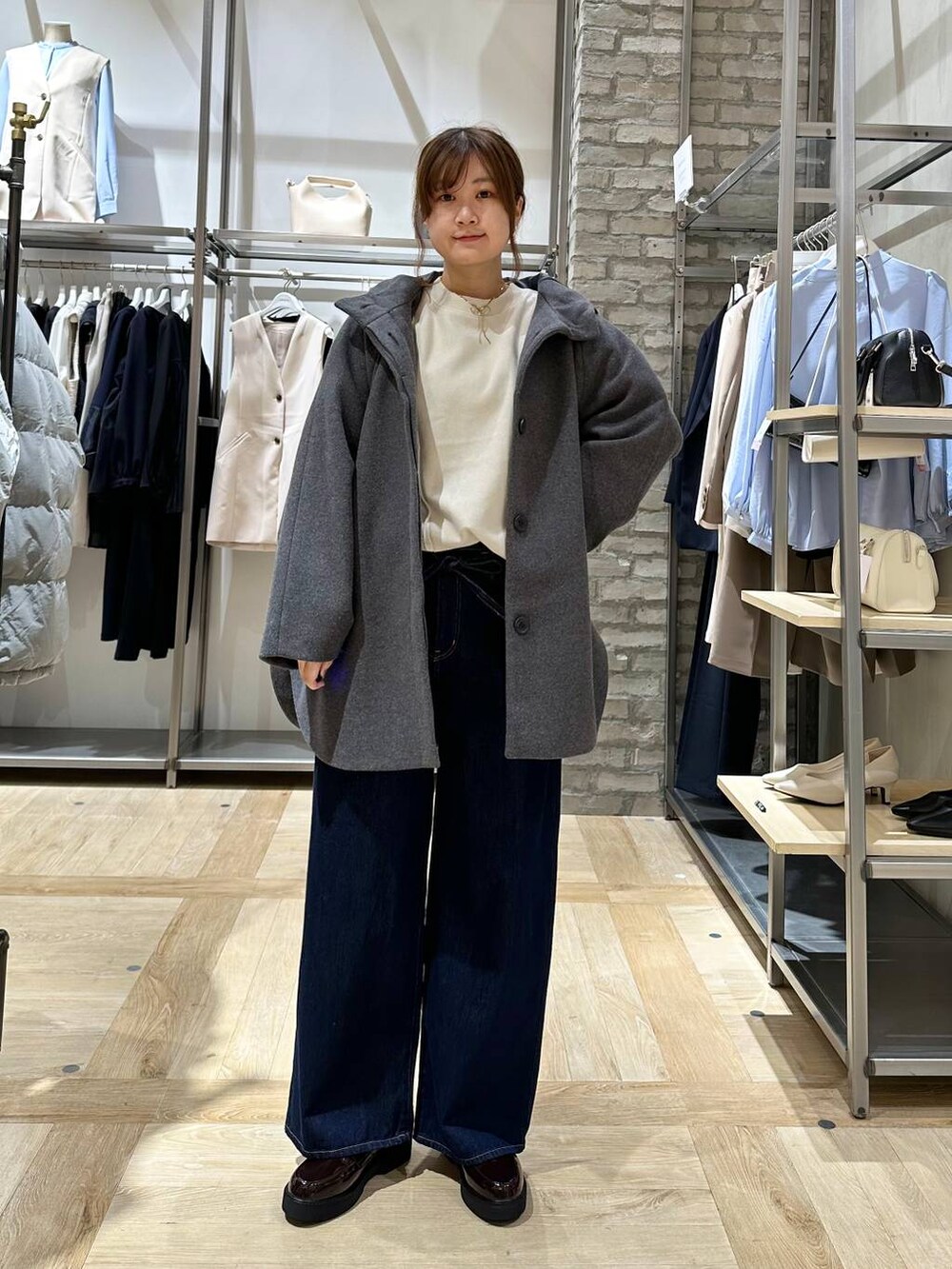 ベージュ系のスウェット、ブラウン系のローファー、ブルー系のデニムパンツを着用したレディースの冬コーディネートの4枚目の写真