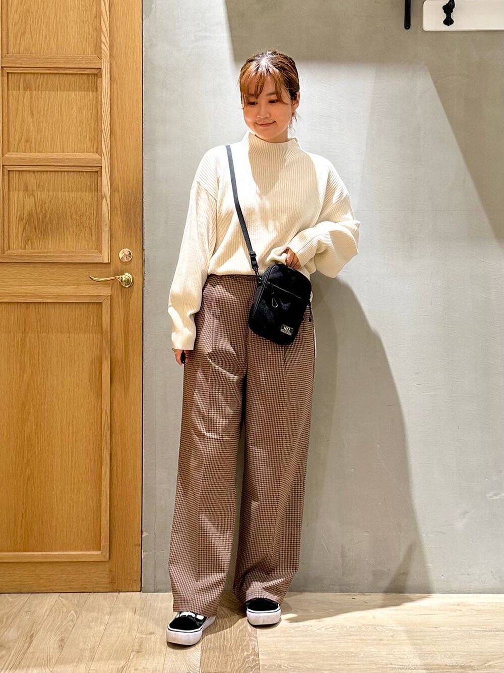 ホワイト系のニット/セーター、ブラック系のショルダーバッグ、ホワイト系のその他アウターを着用したレディースの秋コーディネートの4枚目の写真