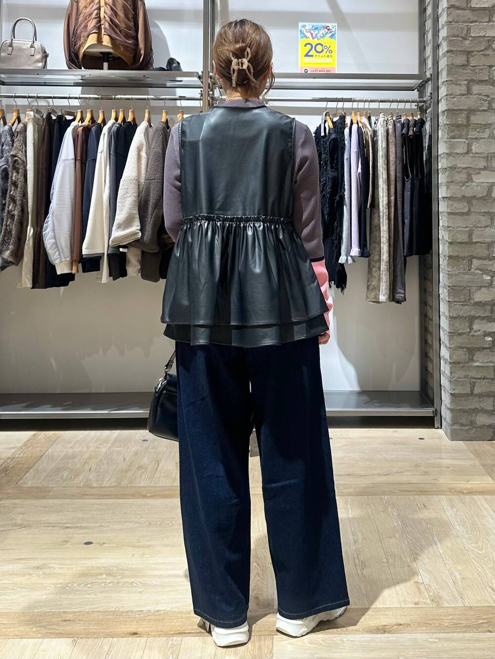 ブルー系のデニムパンツ、グレー系のニット/セーター、ホワイト系のスニーカーを着用したレディースの秋コーディネートの8枚目の写真