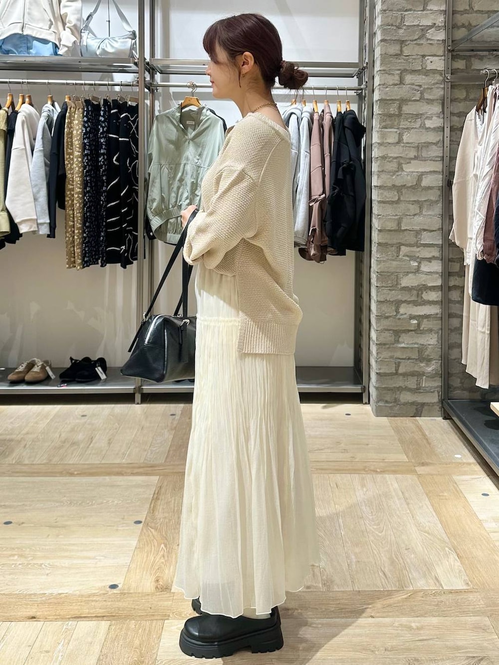 ブラック系のボストンバッグ、ブラック系のその他シューズ、ホワイト系のスカートを着用したレディースの春コーディネートの2枚目の写真