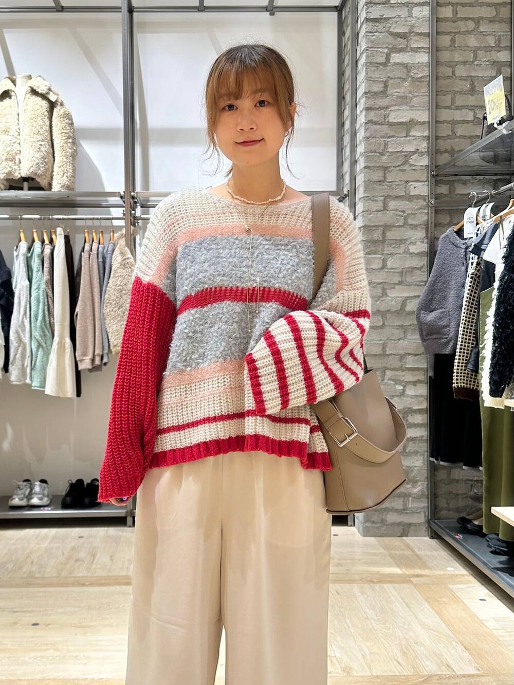 ベージュ系のその他アウター、ホワイト系のその他パンツ、ブラウン系のショルダーバッグを着用したレディースの秋コーディネートの4枚目の写真