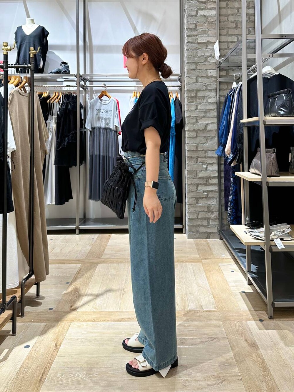 ブラック系のTシャツ/カットソー、ホワイト系のサンダル、ブラック系のショルダーバッグを着用したレディースの夏コーディネートの2枚目の写真