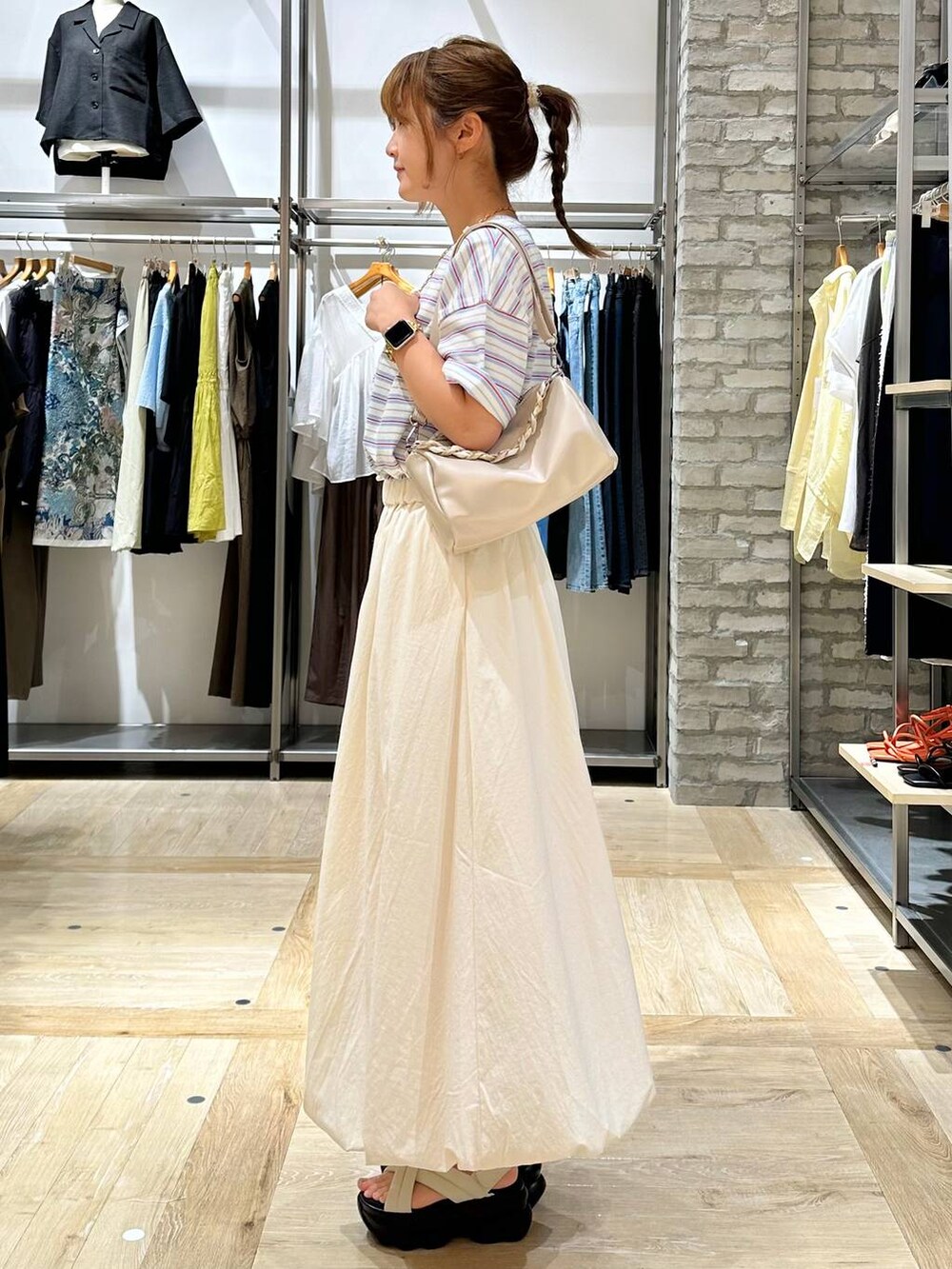 ブルー系のTシャツ/カットソー、ホワイト系のスカート、ホワイト系のショルダーバッグを着用したレディースの夏コーディネートの2枚目の写真