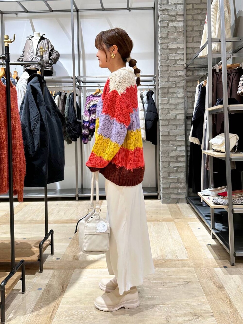 ホワイト系のスカート、ホワイト系のブーツ、ホワイト系のショルダーバッグを着用したレディースの秋コーディネートの3枚目の写真