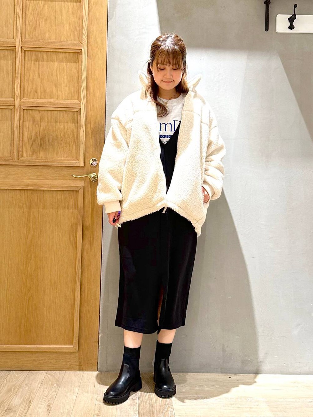 ブラック系のワンピース、ブラック系のブーツ、シルバー系のトートバッグを着用したレディースの冬コーディネートの2枚目の写真