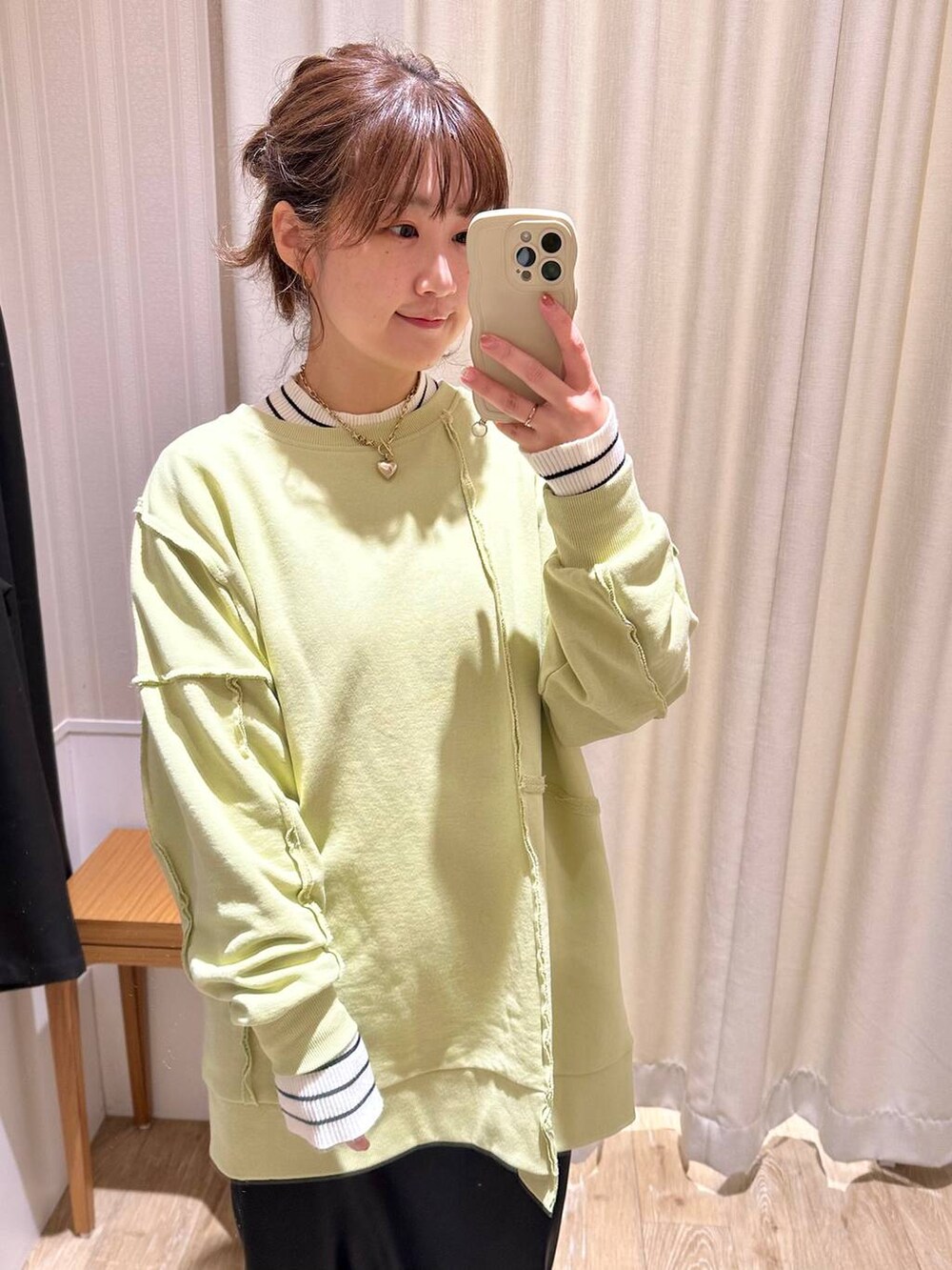 ホワイト系のニット/セーター、ブラック系のスニーカー、グリーン系のチュニックを着用したレディースの冬コーディネートの3枚目の写真