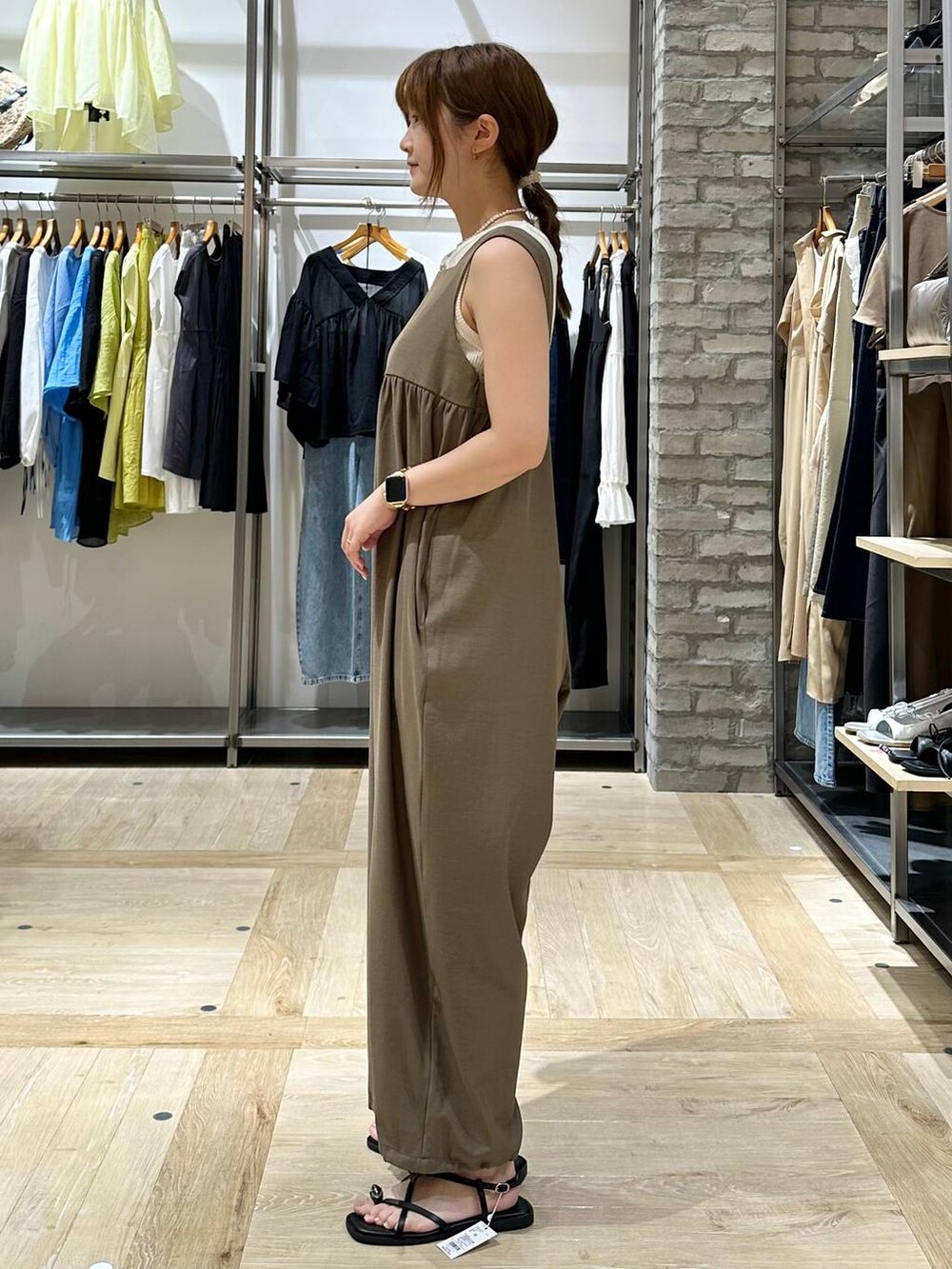 ホワイト系のタンクトップ、イエロー系のつなぎ/オールインワン、ブラック系のサンダルを着用したレディースの夏コーディネートの3枚目の写真