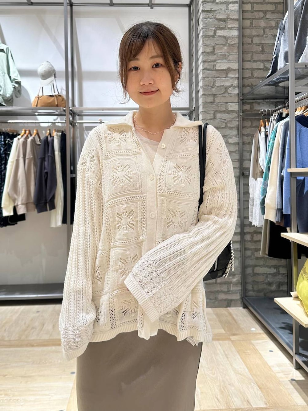 グリーン系のスカート、ホワイト系のTシャツ/カットソー、ブラック系のボストンバッグを着用したレディースの春コーディネートの4枚目の写真