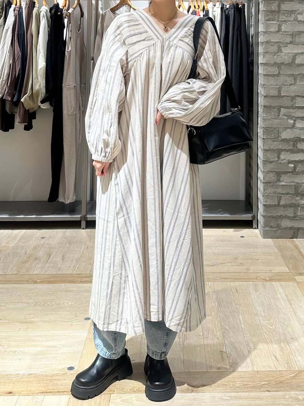 ブラック系のショルダーバッグ、ホワイト系のワンピース、ブラック系のその他シューズを着用したレディースの春コーディネートの6枚目の写真