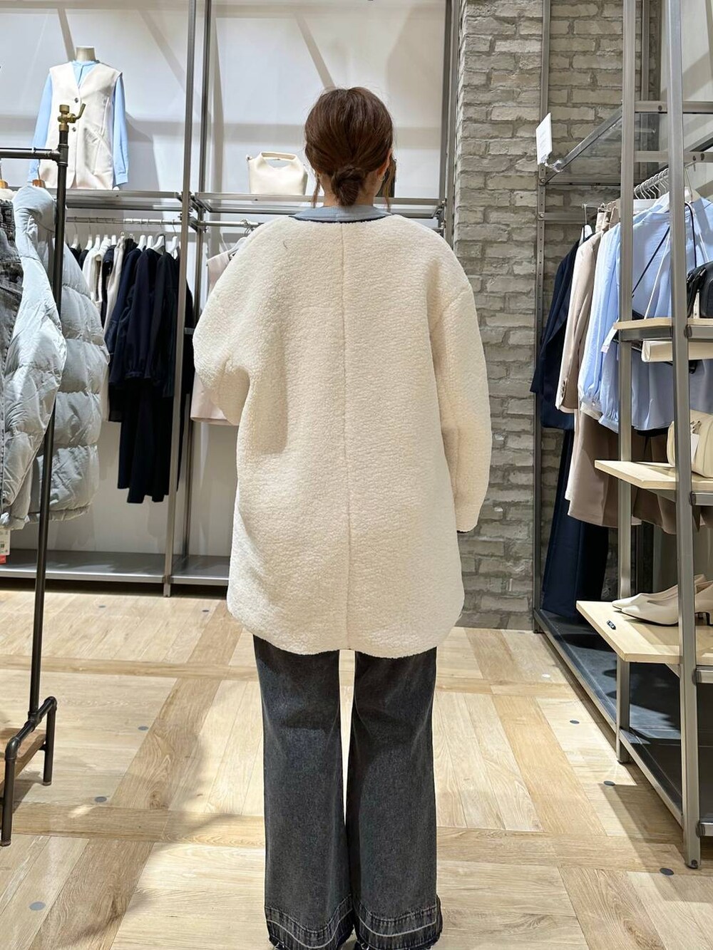 ホワイト系のその他アウター、ブラック系のデニムパンツ、ブラック系のスニーカーを着用したレディースの冬コーディネートの3枚目の写真