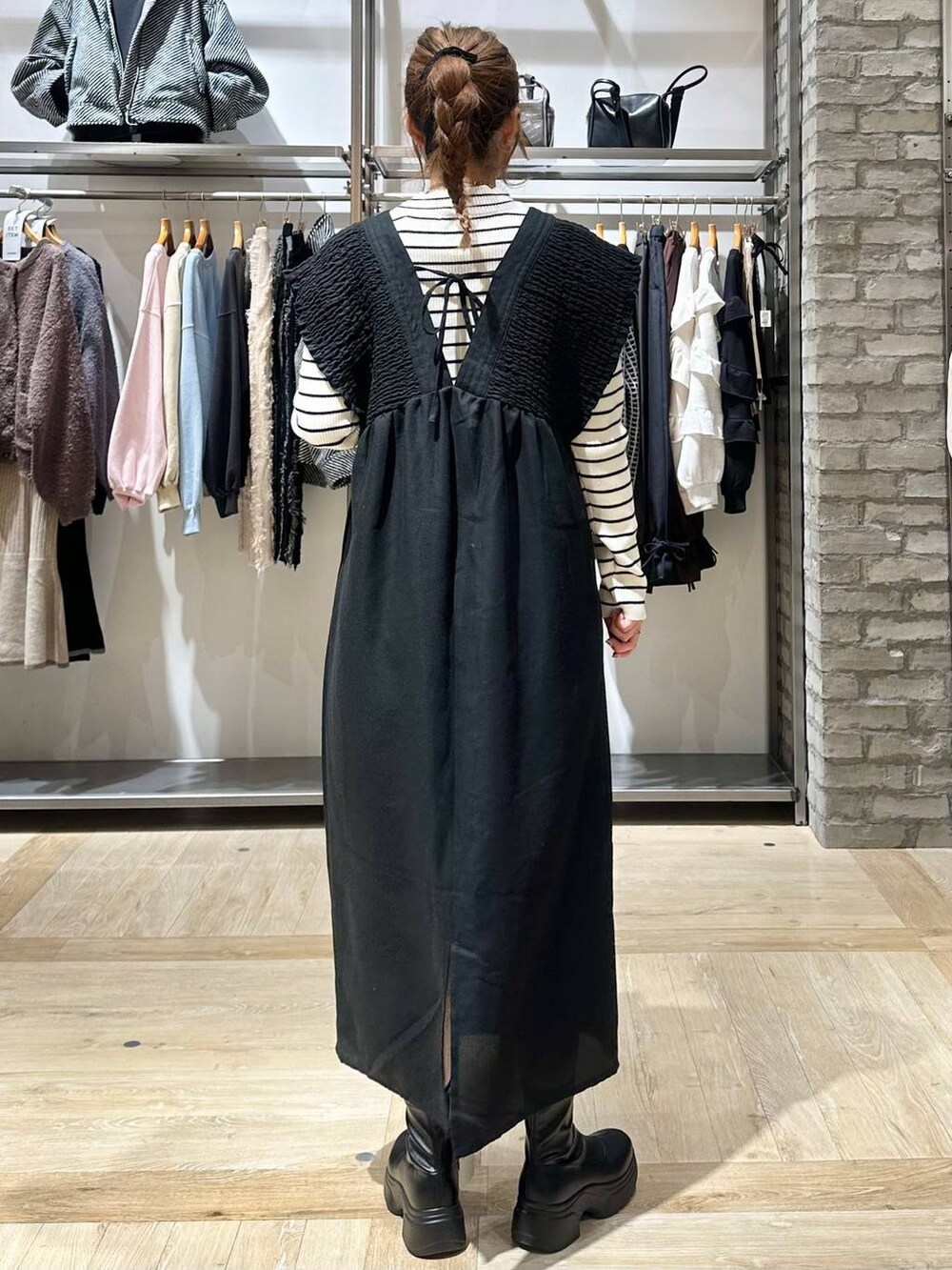 ブラック系のショルダーバッグ、ホワイト系のニット/セーター、ブラック系のブーツを着用したレディースの秋コーディネートの9枚目の写真