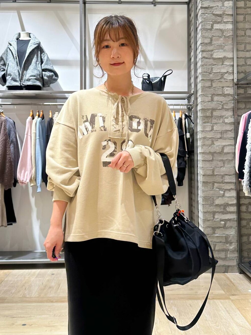 ブラック系のショルダーバッグ、ブラック系のスカート、ホワイト系のその他アウターを着用したレディースの秋コーディネートの5枚目の写真