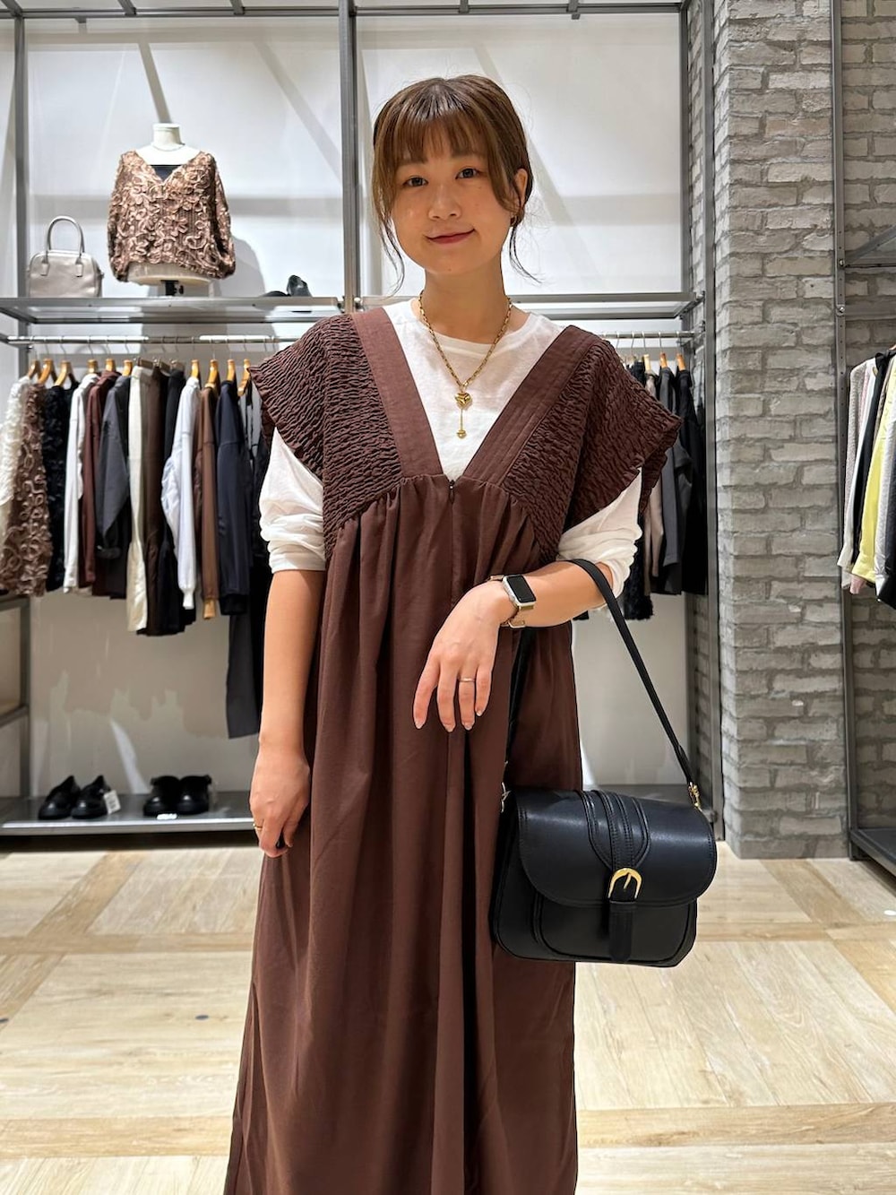 ブラック系のショルダーバッグ、ホワイト系のTシャツ/カットソー、ブラック系のパンプスを着用したレディースの秋コーディネートの4枚目の写真