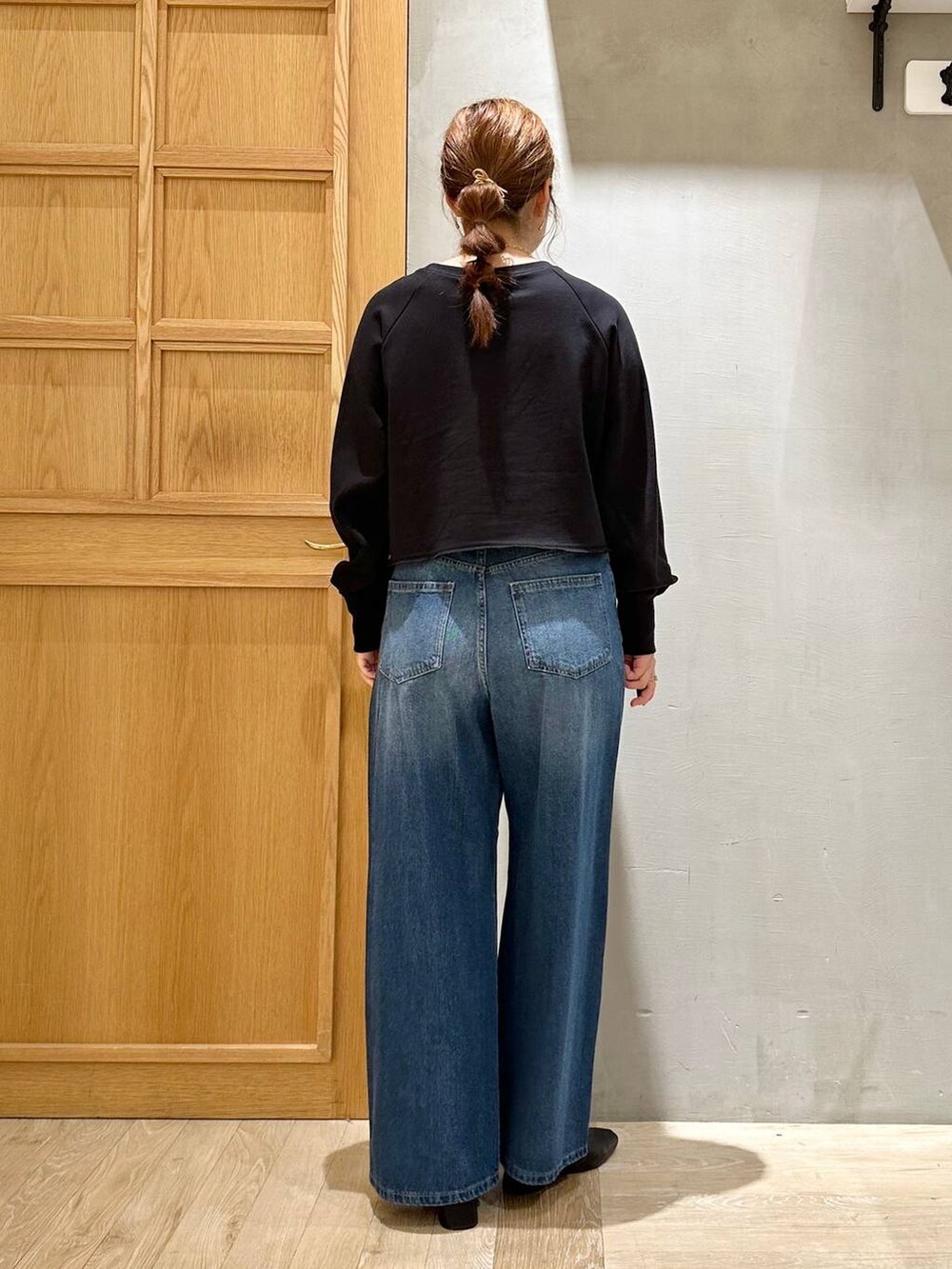 ブラック系のTシャツ/カットソー、ブルー系のデニムパンツ、ベージュ系のショルダーバッグを着用したレディースの秋コーディネートの4枚目の写真