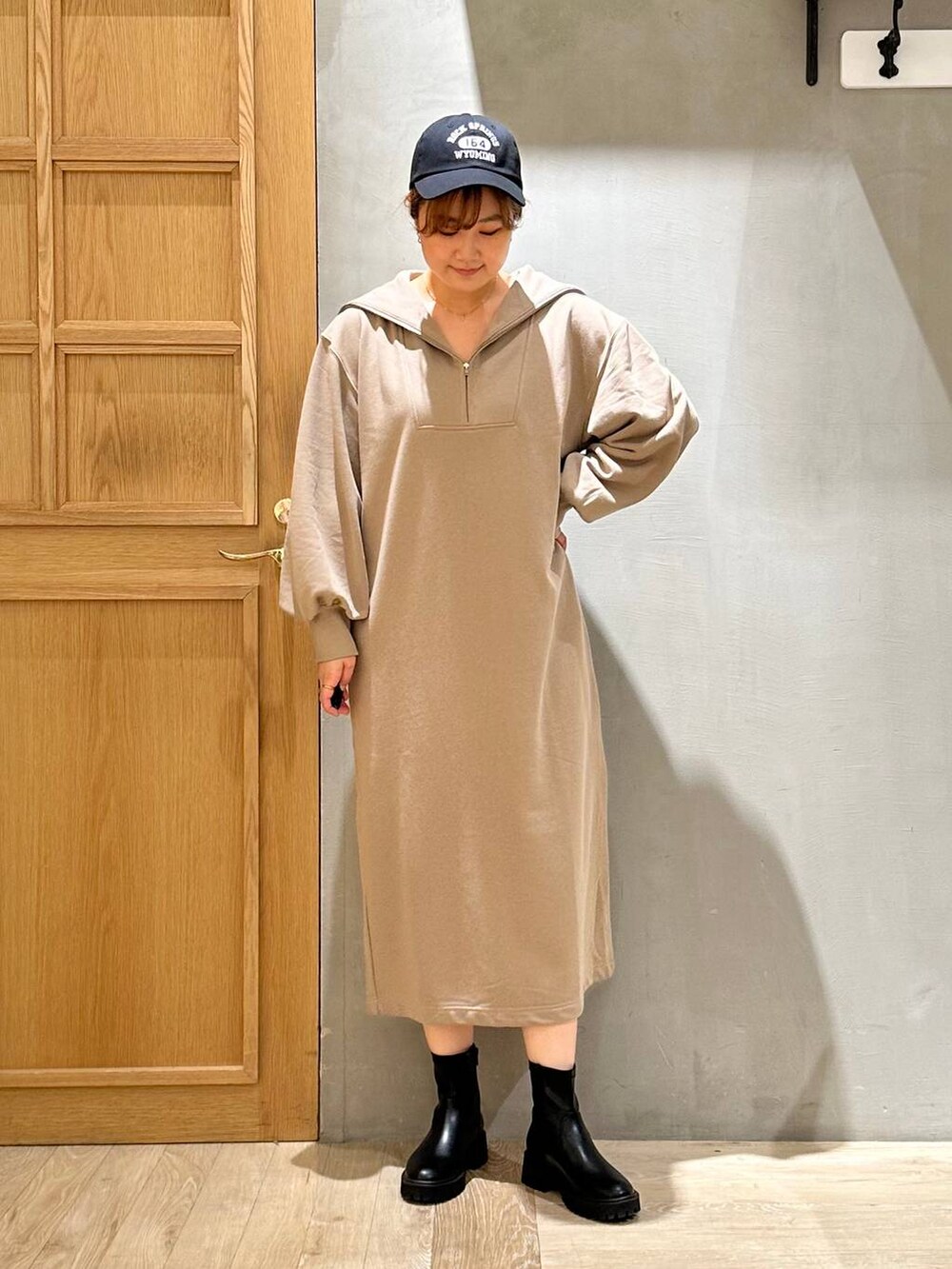 ブラック系のブーツ、ブラック系のショルダーバッグ、ブラウン系のワンピースを着用したレディースの秋コーディネートの2枚目の写真