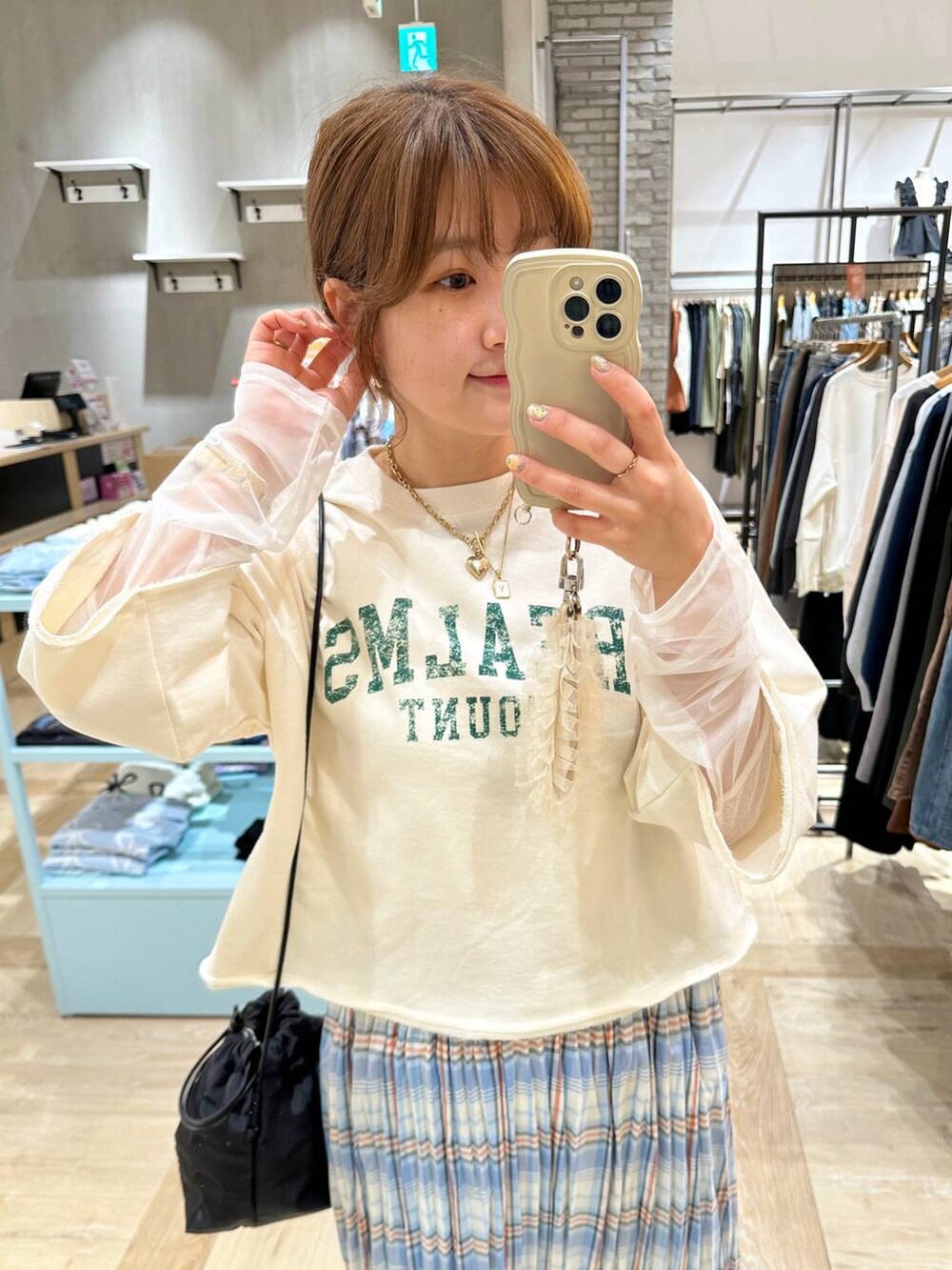 ホワイト系のTシャツ/カットソー、ブラック系のショルダーバッグ、ブルー系のデニムパンツを着用したレディースの春コーディネートの4枚目の写真