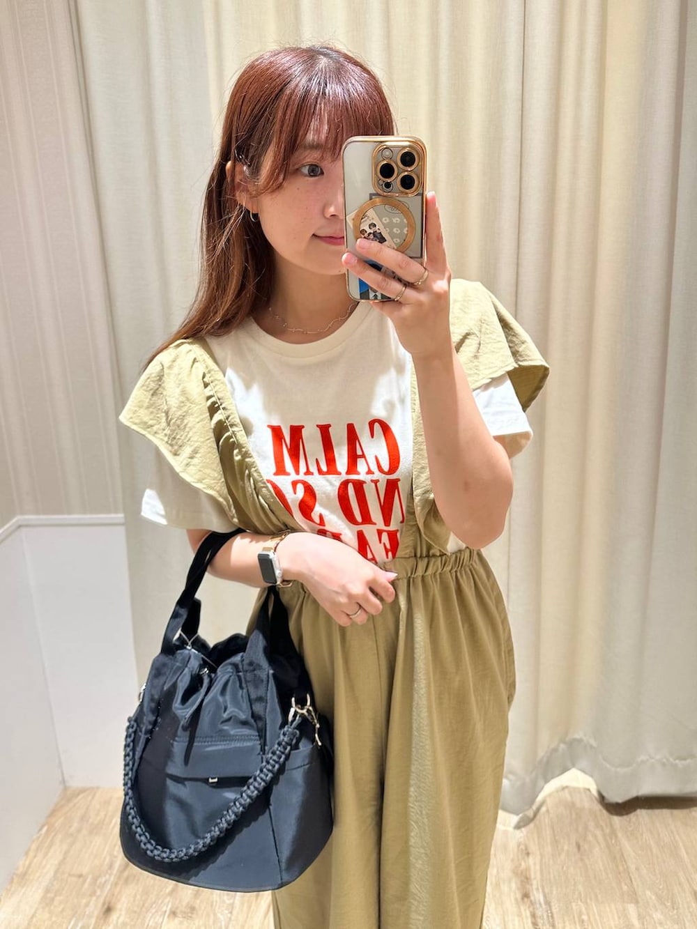 ブラック系のショルダーバッグ、ブラック系のサンダル、ホワイト系のTシャツ/カットソーを着用したレディースの夏コーディネートの3枚目の写真