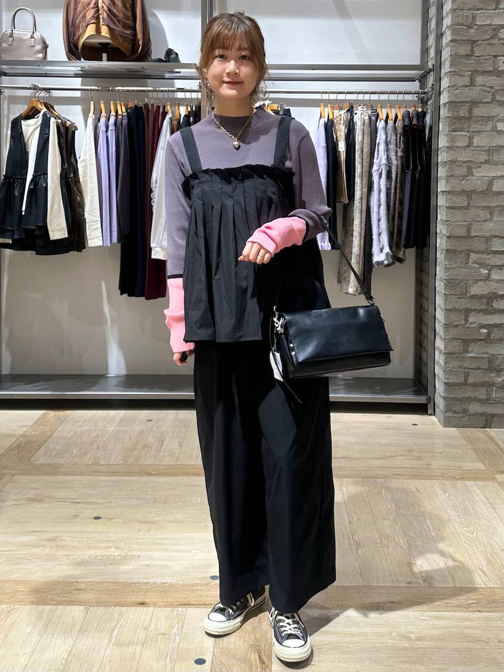 グレー系のニット/セーター、イエロー系のスニーカー、ブラック系のショルダーバッグを着用したレディースの秋コーディネートの2枚目の写真