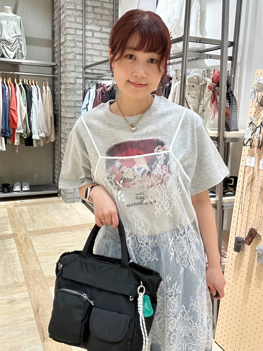 ブルー系のデニムパンツ、ブラック系のトートバッグ、ブラウン系のサンダルを着用したレディースの春コーディネートの4枚目の写真