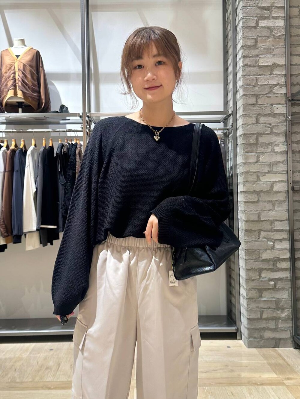 ブラック系のニット/セーター、ブラック系のスニーカー、ホワイト系のその他パンツを着用したレディースの秋コーディネートの5枚目の写真