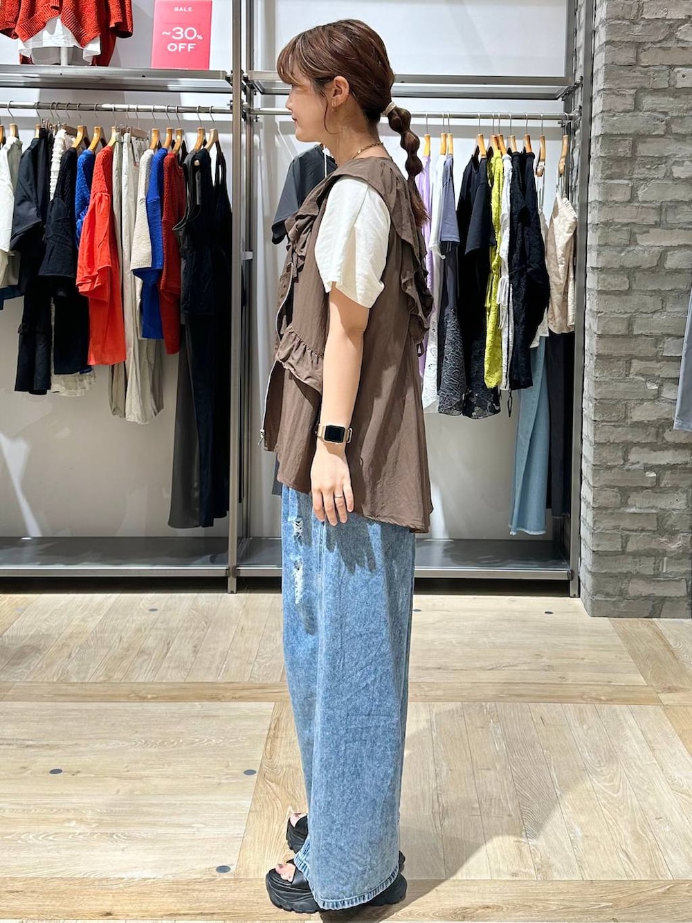 ブラウン系のベスト、ブルー系のデニムパンツ、ホワイト系のTシャツ/カットソーを着用したレディースの夏コーディネートの2枚目の写真