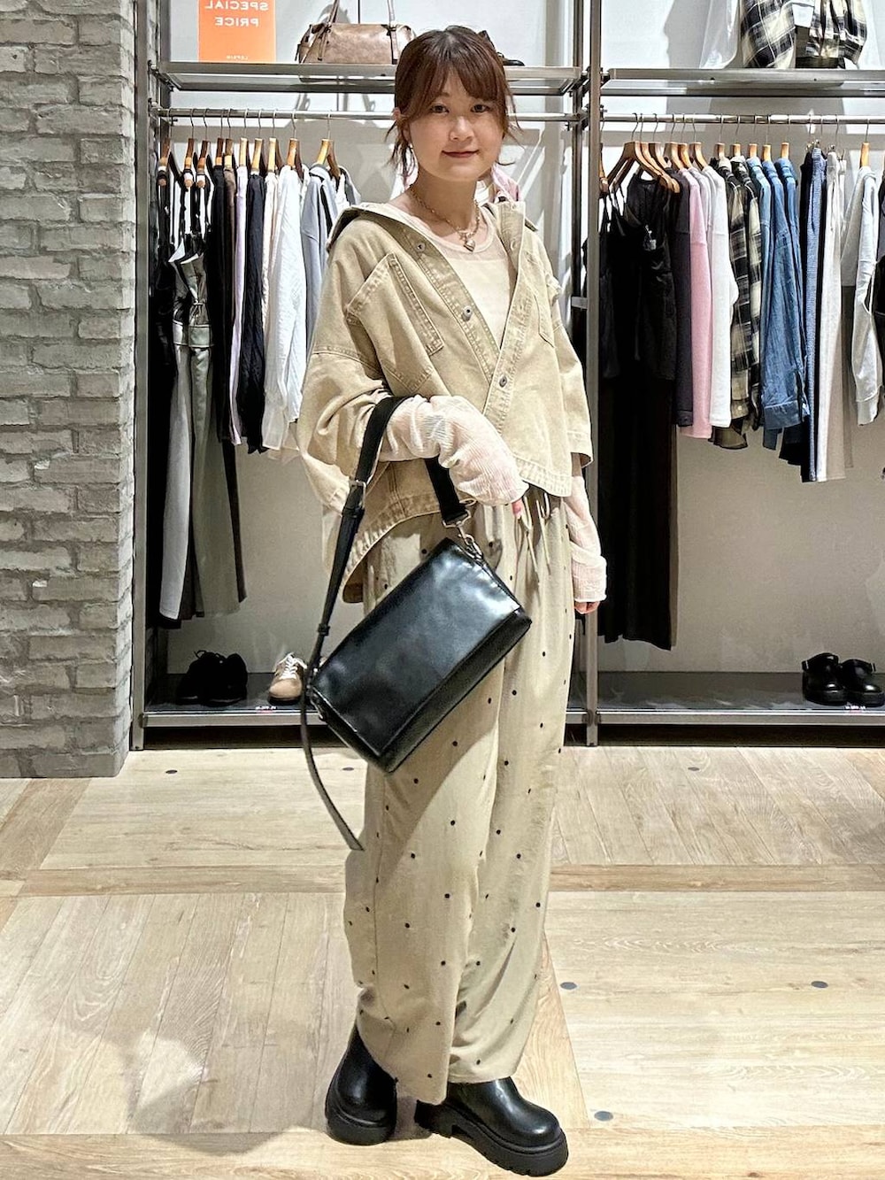 ブラック系のショルダーバッグ、ブラック系のその他シューズ、ホワイト系のTシャツ/カットソーを着用したレディースの春コーディネートの2枚目の写真