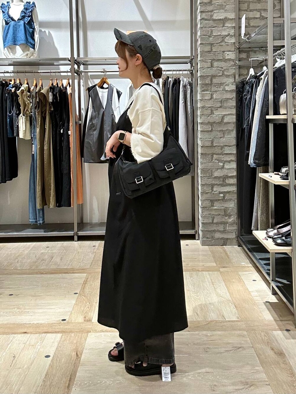 ブラック系のデニムパンツ、ブラック系のショルダーバッグ、ブラック系のサンダルを着用したレディースの春コーディネートの2枚目の写真