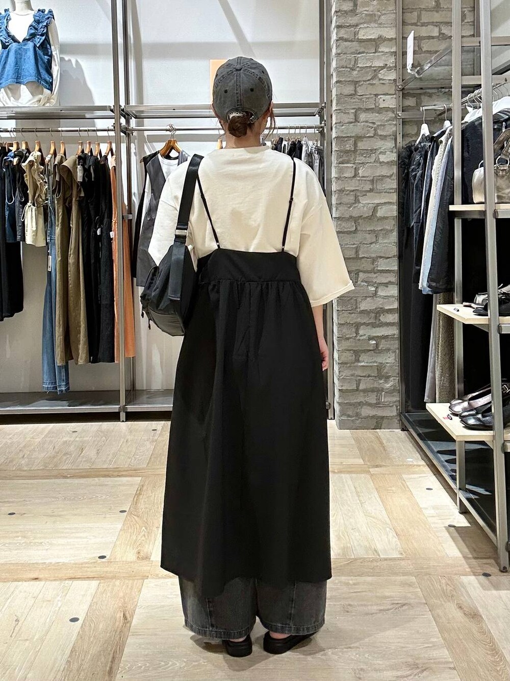 ブラック系のデニムパンツ、ブラック系のショルダーバッグ、ブラック系のサンダルを着用したレディースの春コーディネートの3枚目の写真