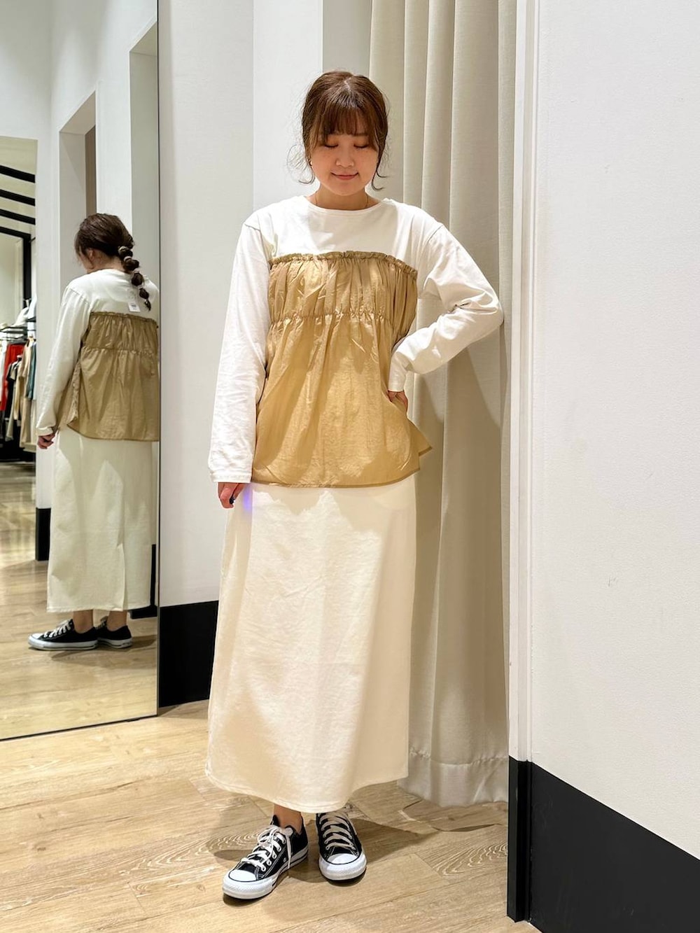 ホワイト系のスカート、ブラック系のショルダーバッグ、ベージュ系のTシャツ/カットソーを着用したレディースの春コーディネートの3枚目の写真