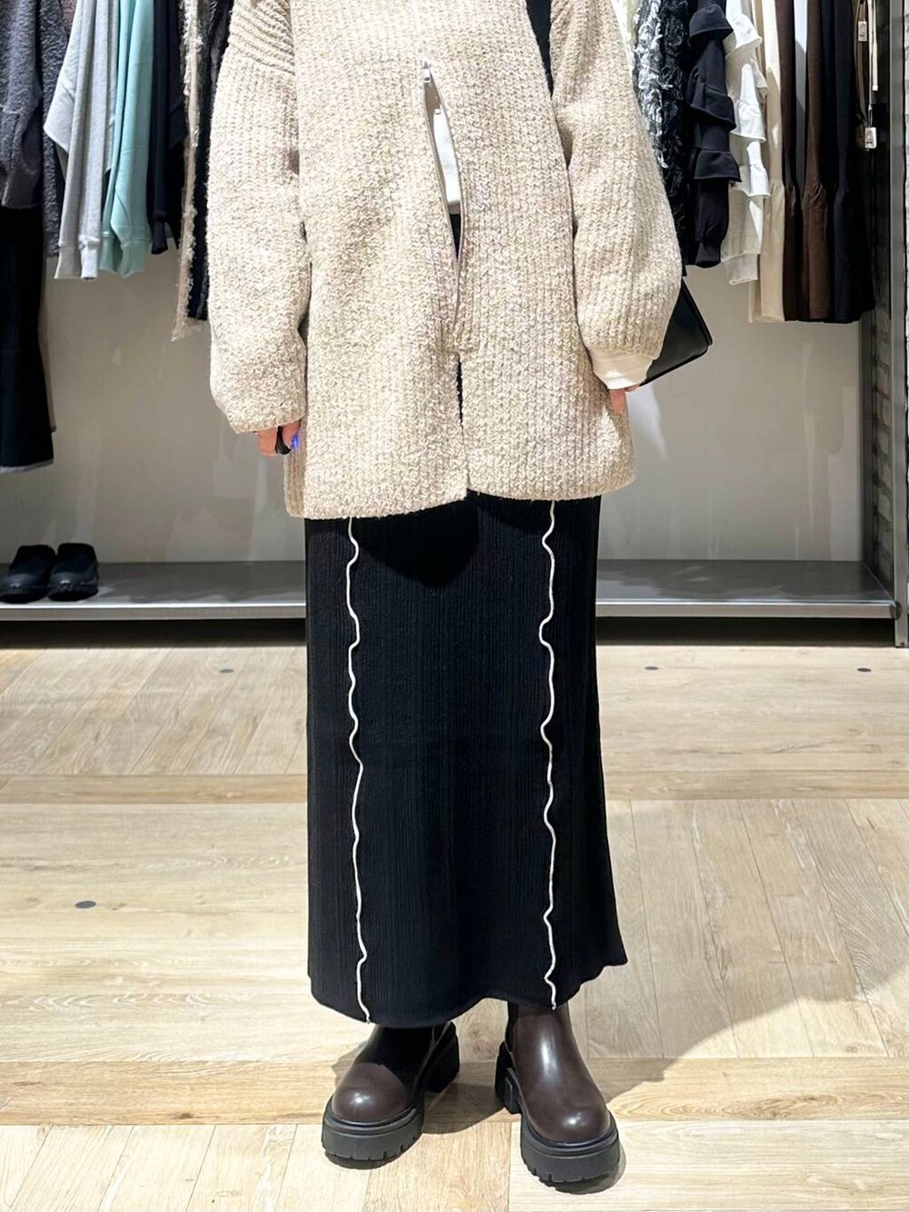 ブラウン系のブーツ、ホワイト系のTシャツ/カットソー、ブラック系のショルダーバッグを着用したレディースの秋コーディネートの6枚目の写真